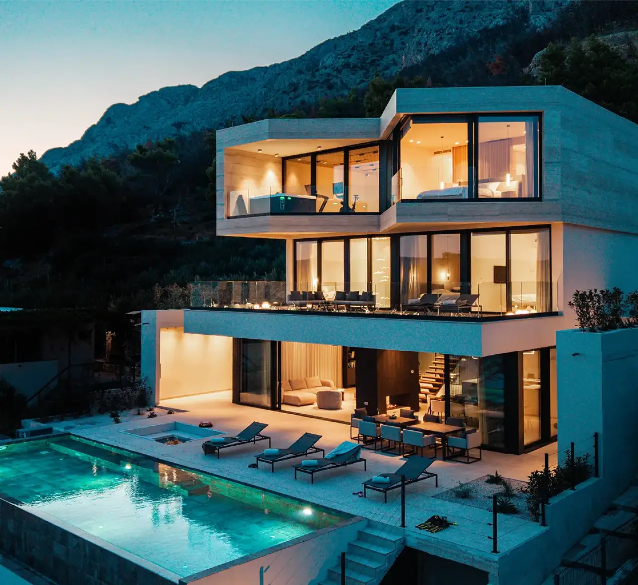 Moderne Luxusvilla mit beleuchtetem Innenraum und privatem Pool